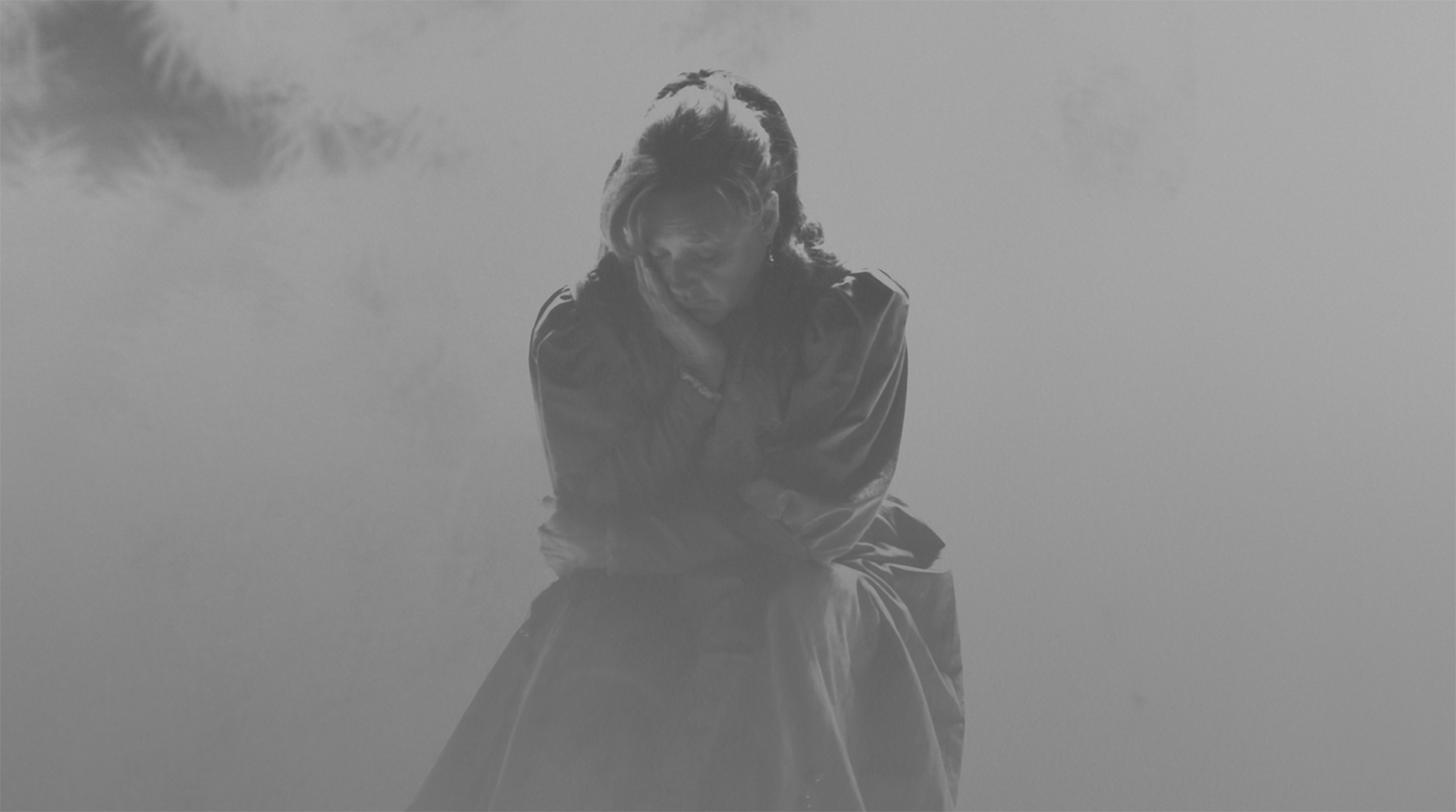 Woman with head in hand in black and white