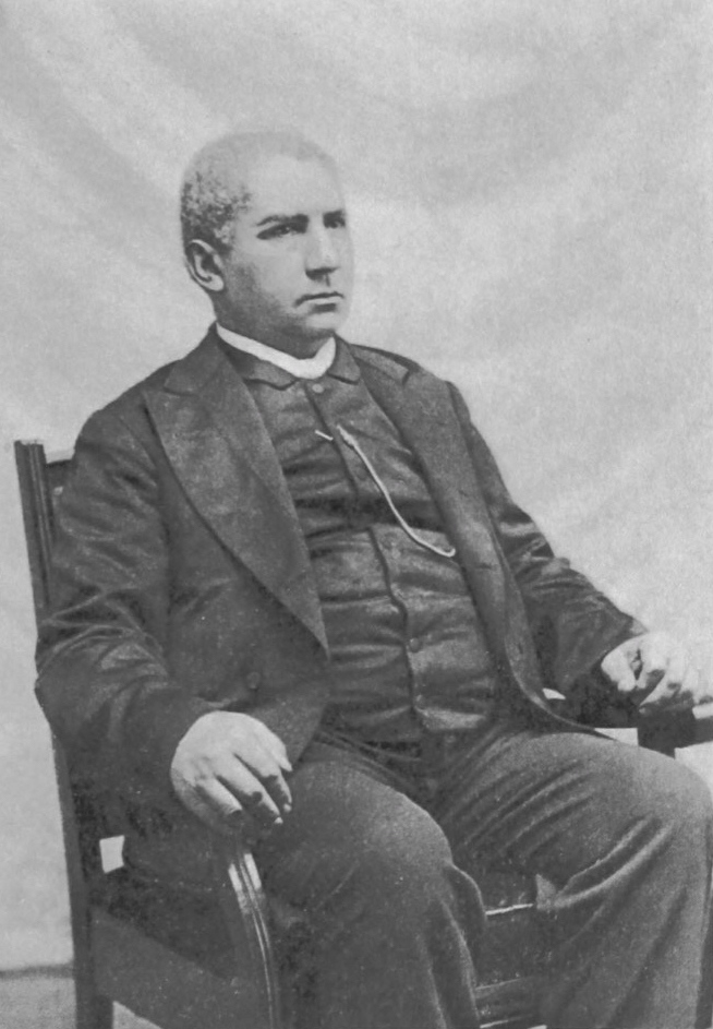 Black and white photograph of Henry McNeal Turner, seated in a chair, facing slightly away from the camera
